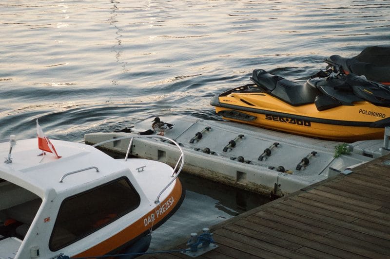 A boat and personal watercraft at the dock