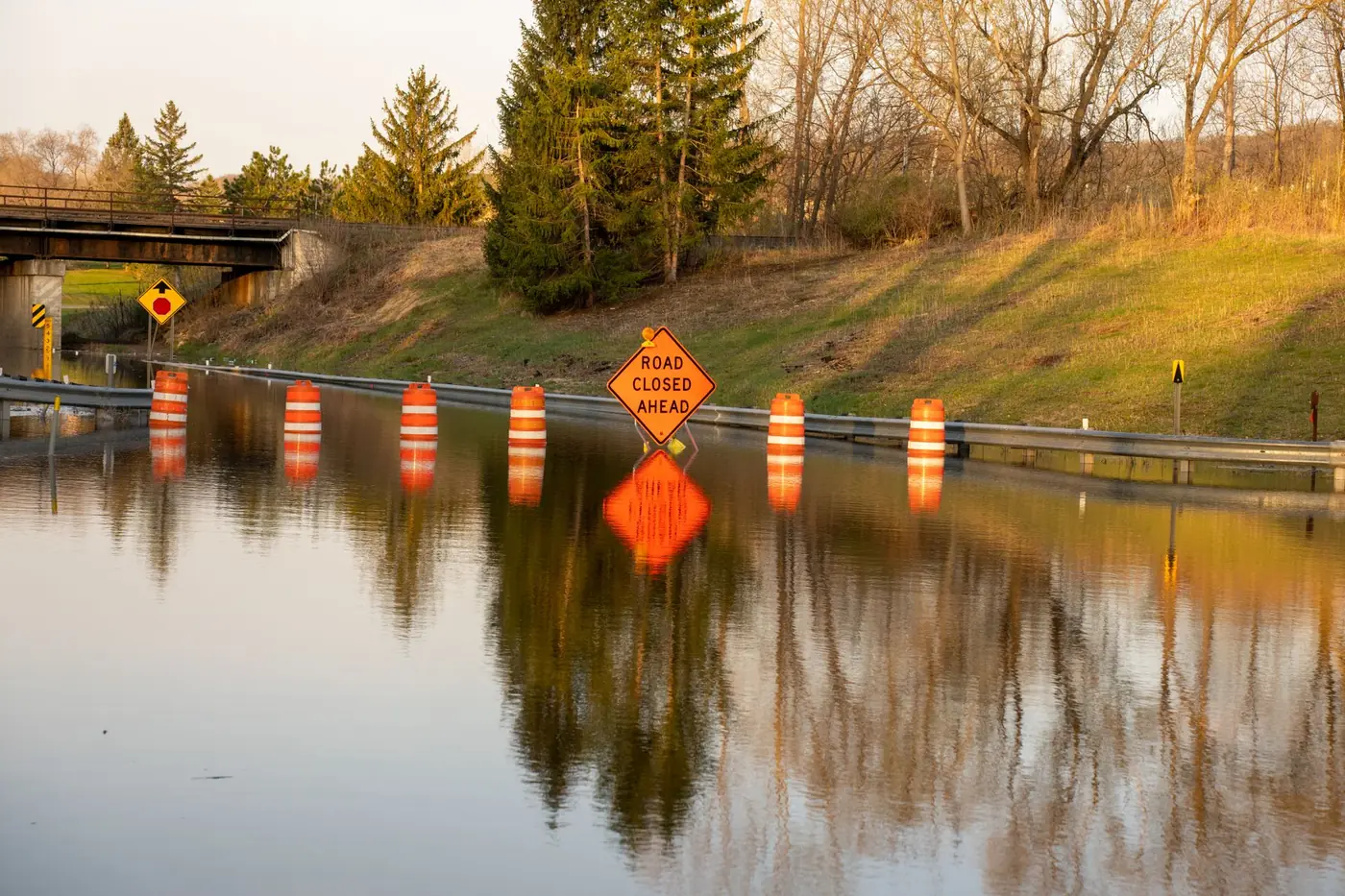 What to do in a flood: road closed sign and barrels on a flooded road