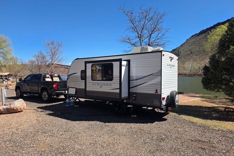A travel trailer towed to a lakeside campground